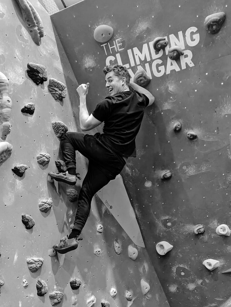 Sean bouldering, looking back over his shoulder